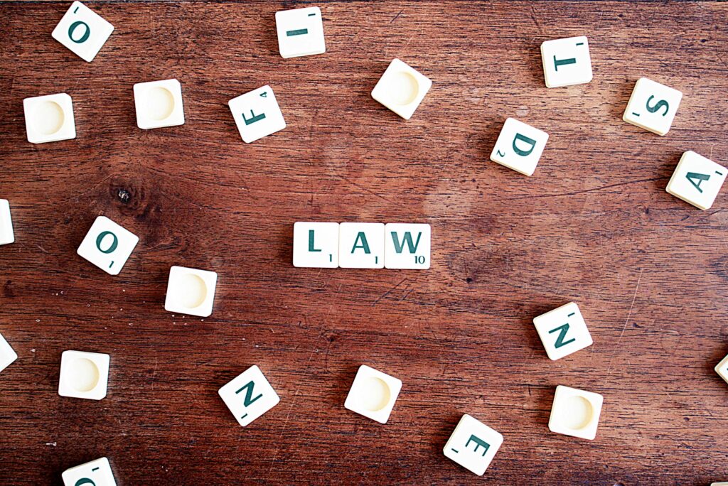 pexels-photo-613508-613508 Scrabble tiles spelling 'LAW' on a wooden table, symbolizing connections to education and legality.