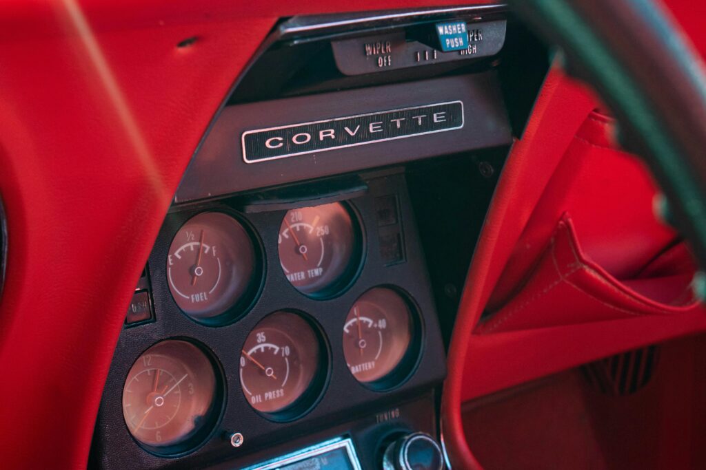 Close-up of a vintage Chevrolet Corvette dashboard showcasing gauges and details.